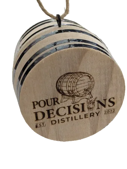 A natural wood barrel ornament with engraved logo of Pour Decisions Distillery, hanging from a metal chain.